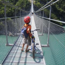 Les enfants passent sur les passerelles himalayennes à vélo